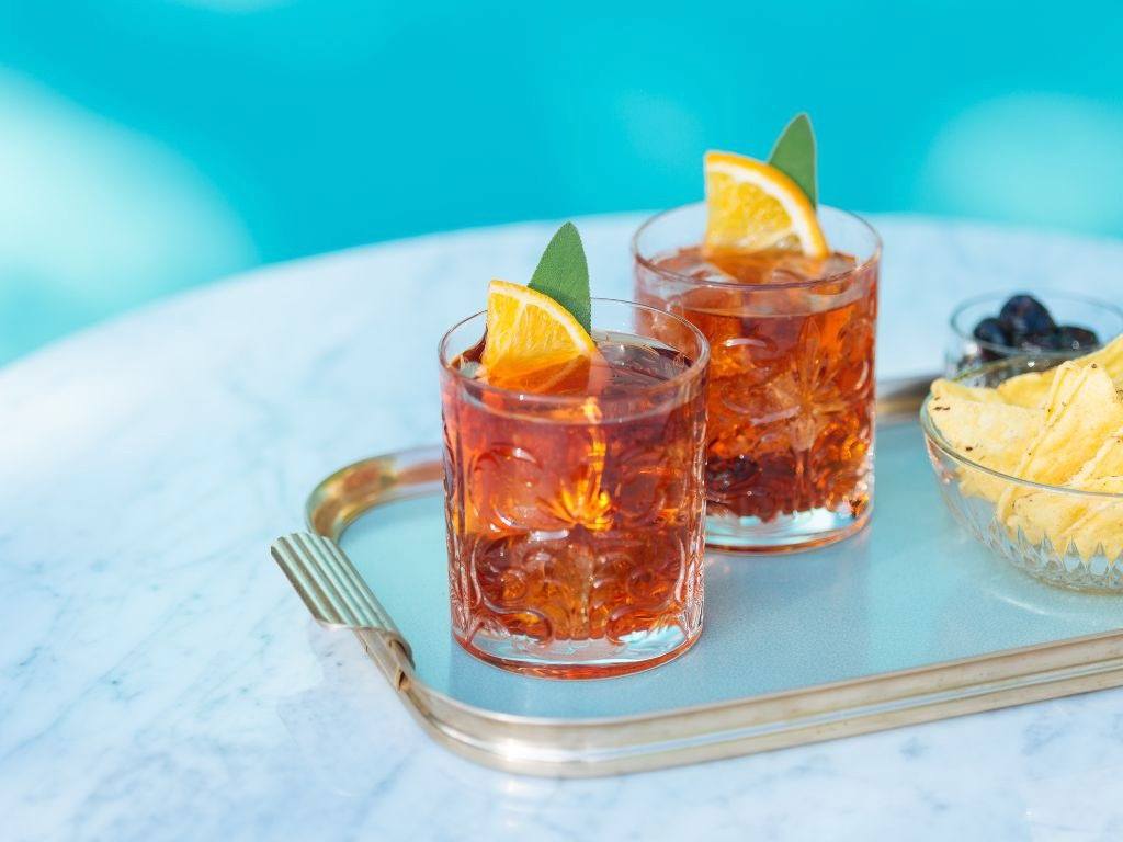 Negroni cocktails on a tray against a blue background