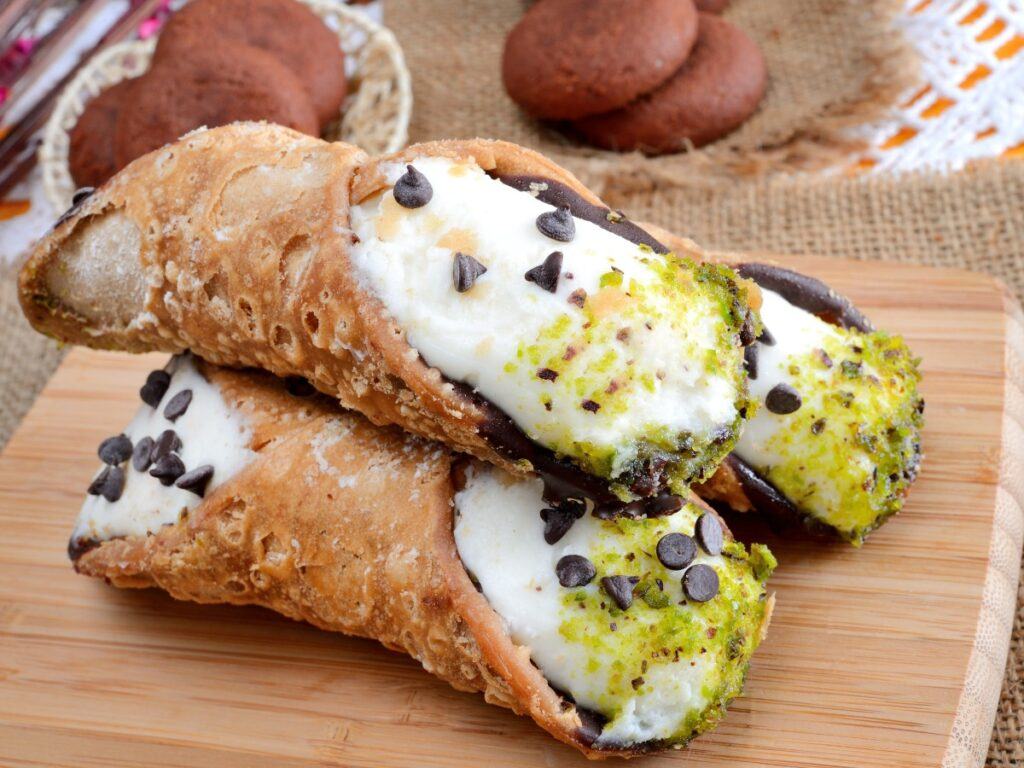 Pile of cannoli with ends dipped in lime zest an chocolate chips